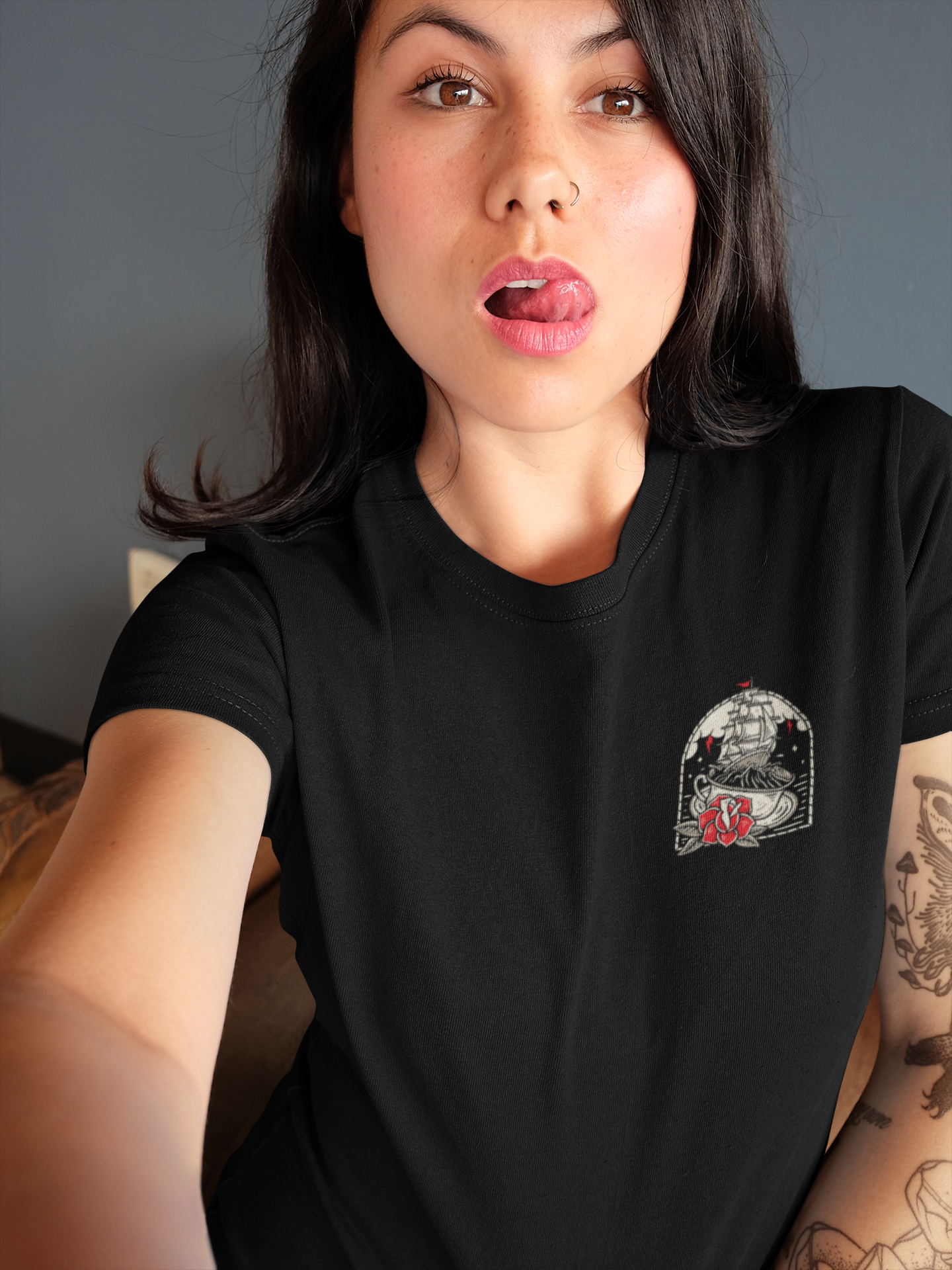 Woman wearing a black t-shirt with a graphic design on a neutral background